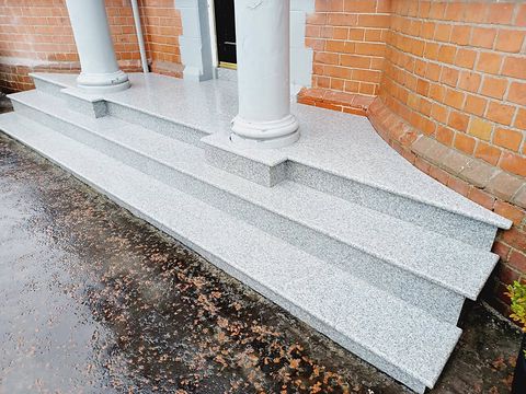 Silver granite steps and landing built between rendered pillars