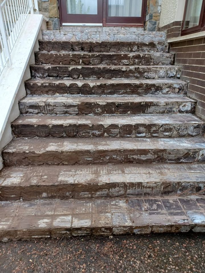 The steps before work: cracked, worn concrete and crumbling brick treads