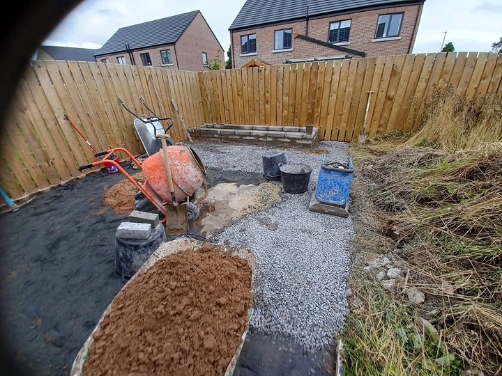 The same garden mid-build, with membrane, compacted hardcore base and a new block retaining wall
